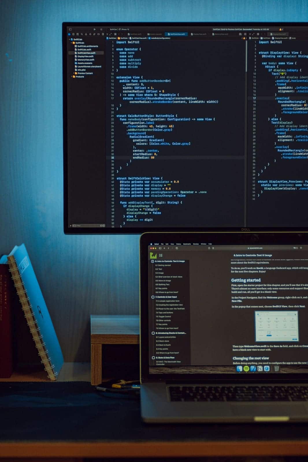 Code editor open on a desktop monitor above a laptop