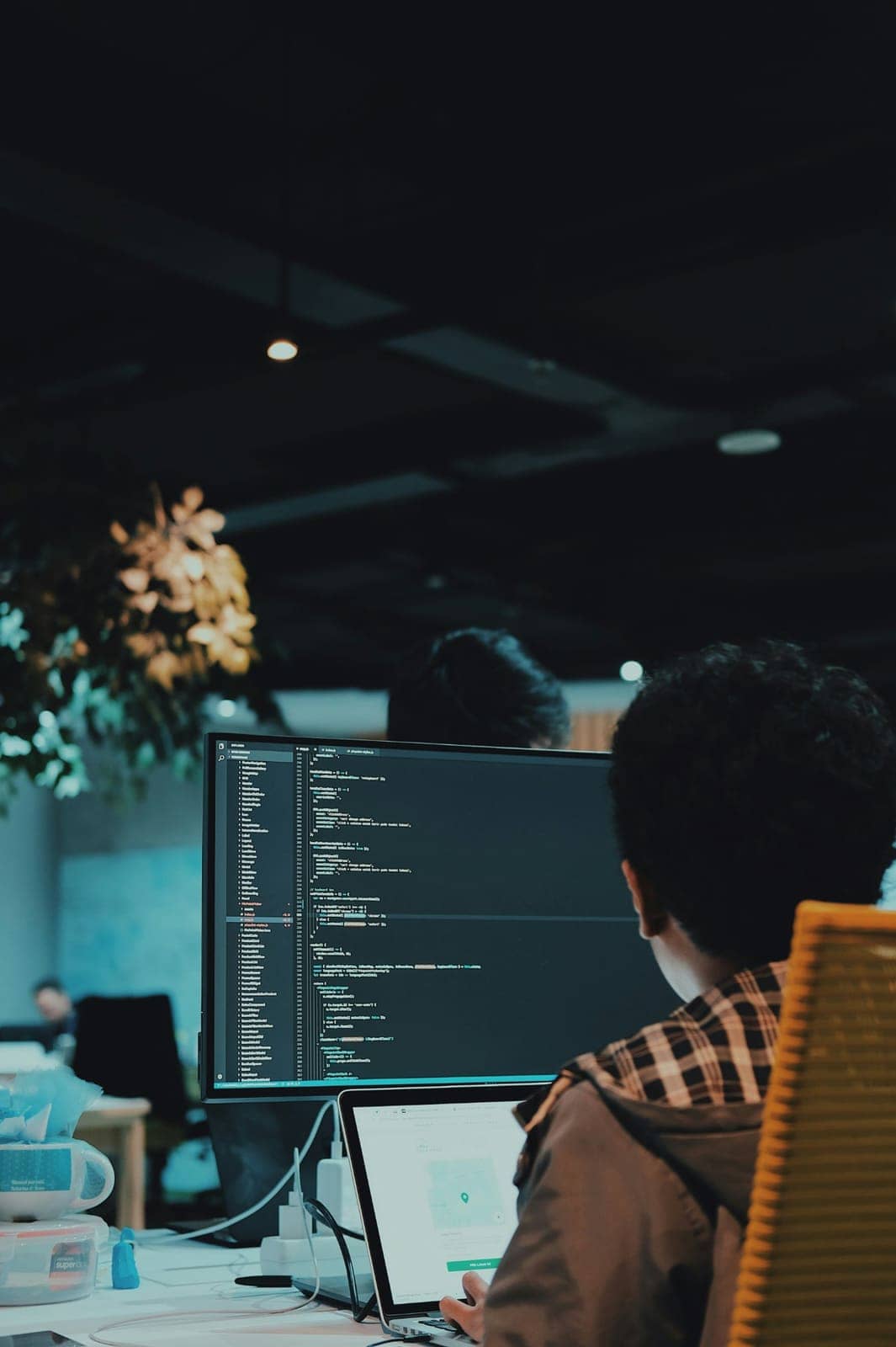 Developer working at a desk with code on a large monitor